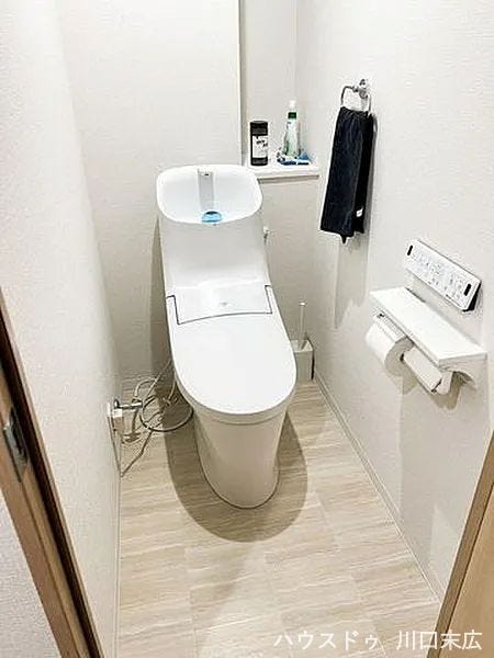 温水洗浄便座を備えた清潔感のあるレストルーム。操作性の高い壁付けリモコンを採用し、快適な使い心地を追求しています。