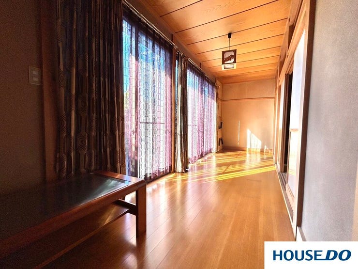 陽光がたっぷりと差し込む、明るく開放的な広縁です。木の温もりを感じる天井と、艶やかなフローリングが高級感を演出。お庭の景色を眺めながら、ゆったりと日向ぼっこを楽しめる贅沢な空間です。