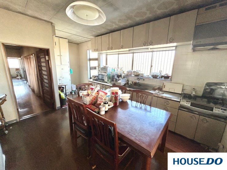 大きな窓から陽光が差し込む、明るく開放的なダイニングキッチンです。壁一面に豊富な収納を備え、調理器具や食器もスッキリ整理可能。家族で食卓を囲めるゆとりある広さで、家事動線もスムーズな使いやすい空間です