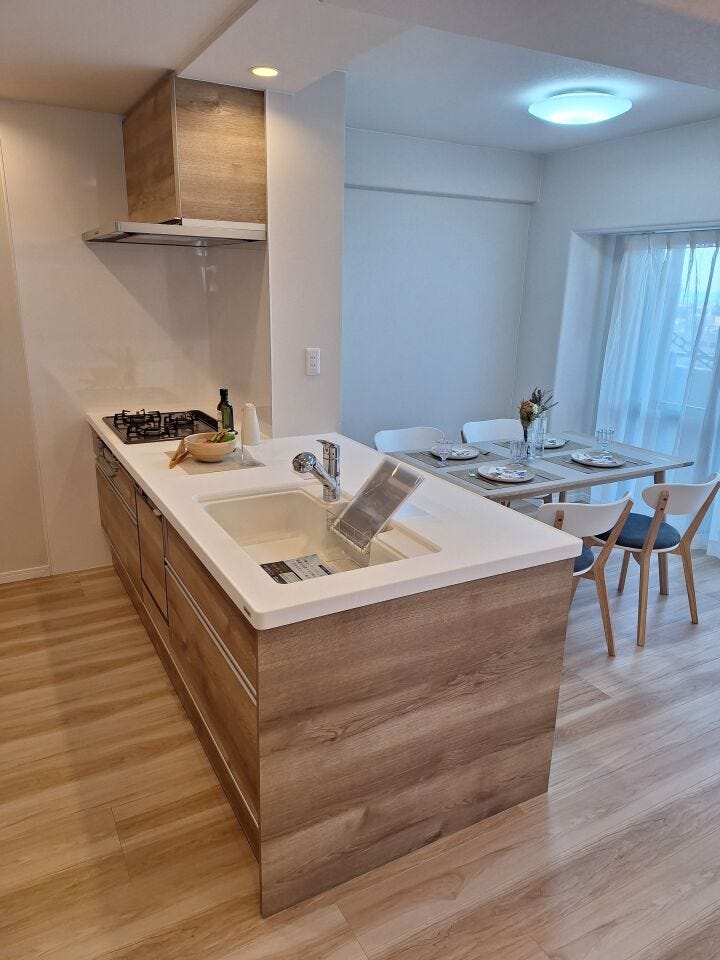 【キッチン】
対面式のペニンシュラ型キッチン。オール引き出し収納となっています。ビルトイン食洗器完備。白い人工大理石調のシンクはインテリア性が高く明るい印象です。