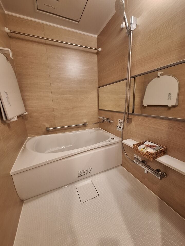 明るい木目調のユニットバス。横長のワイドミラー仕様。浴室暖房換気乾燥機は洗濯物干しにも役立ちます。