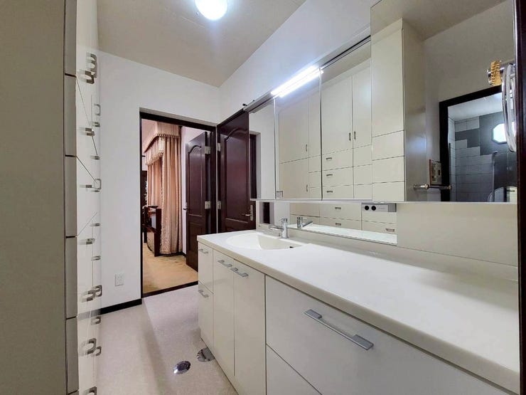 大きな三面鏡付きの洗面台は、白を基調としたシンプルな造りで、清潔感がありますね。