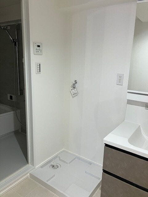 洗面台の横に配置された効率的な動線の洗濯機置き場
防水パンも設置済みで、水漏れなどのトラブルにも配慮された設計です