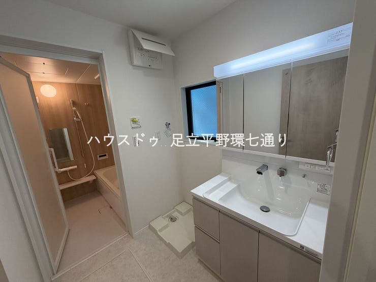 三面鏡付き洗面化粧台で収納力充実。洗濯機置場も確保された使いやすい洗面室です。