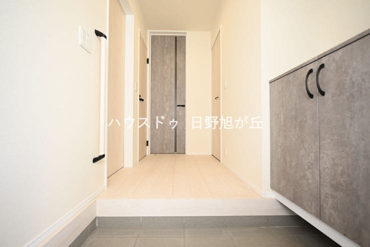 白を基調とした、清潔感と開放感あふれる玄関スペース。手すり付きで、ご年配の方やお子様の移動も安心です。上質な素材感のフローリングが続き、家族やゲストを温かく迎えてくれる住まいの顔となっています。