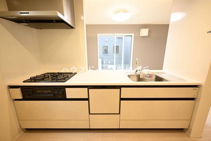 食洗機や3口ガスコンロを標準装備した機能的なシステムキッチン。足元までたっぷり入るスライド収納を採用し、出し入れも楽々です。背面のスペースも広く、冷蔵庫やカップボードを自由に配置いただけます。