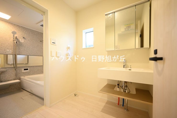 洗面室には、収納力抜群の三面鏡付きシャンプードレッサーを設置。下部にも棚があり、リネン類やストック品の整理に役立ちます。窓があり換気もしやすく、白を基調とした清潔感あふれるサニタリー空間です。