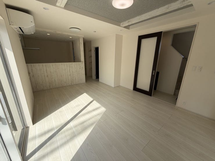 大きな窓から陽光が差し込む明るいLDK。折上げ天井が空間に広がりを演出し、家族がゆったり過ごせる開放的な空間です。