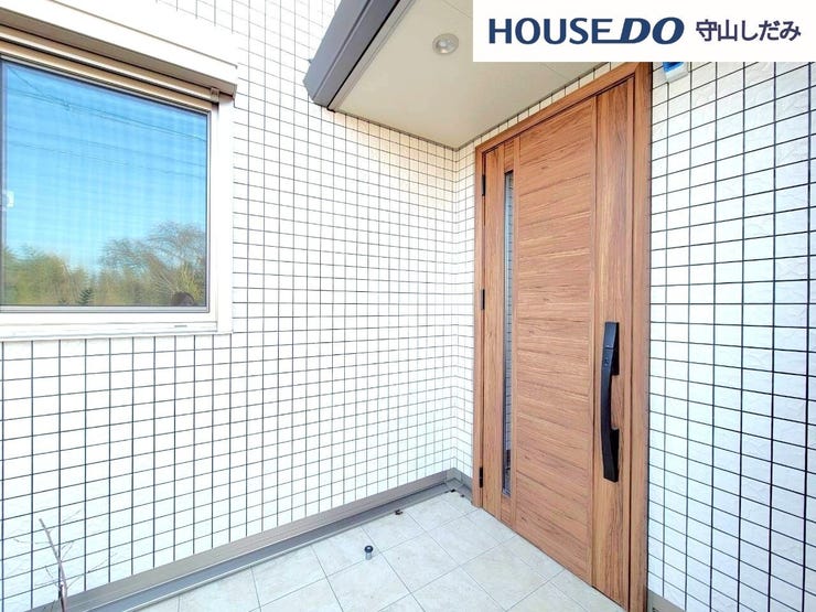 【玄関ポーチ】外観から見える玄関扉は木目調のデザインを採用し、住まい全体に温かみのある印象を与えています。街並みにも自然になじみ、帰宅するたびにやさしい気持ちになれる佇まいです。