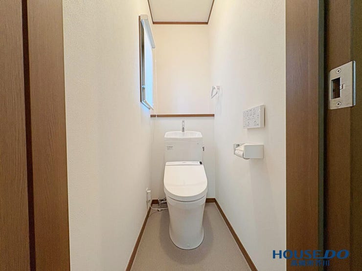 白を基調とした壁紙で清潔感のあるトイレ