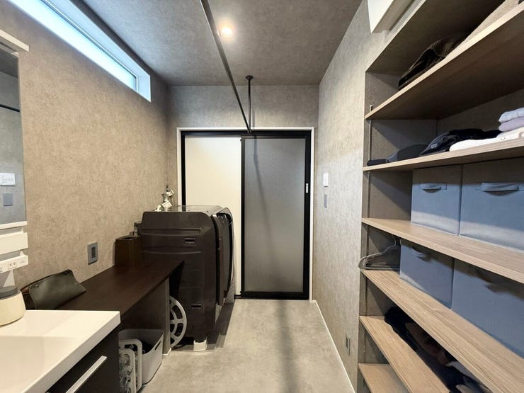 脱衣所に収納力抜群の稼働棚と、室内干し用のハンガーパイプが設置されています。