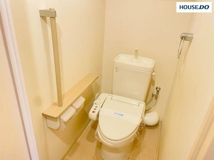 縦型の手すりが設置されています。トイレットペーパーホルダーが「棚付き」なので、スマホを一時置きしたりするのにも非常に便利です。