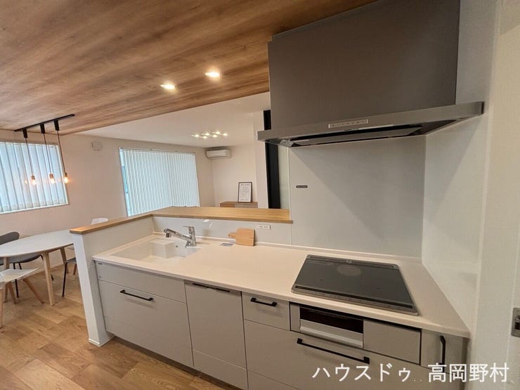 木目天井と間接照明が空間をおしゃれに演出するキッチン。
リビングを見渡せる対面式で、家族との会話も自然と弾みます。