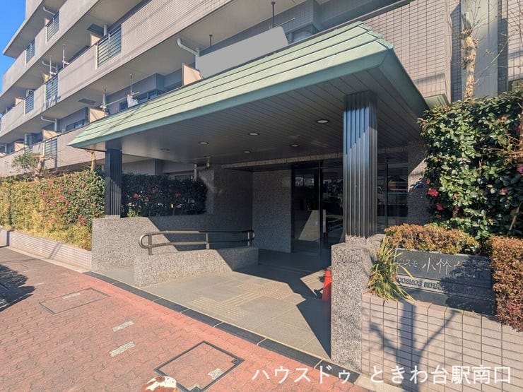 屋根付きのエントランスが雨天時の出入りをサポート。重厚感のある造りで、来訪者にも落ち着いた印象を与える共用空間です。