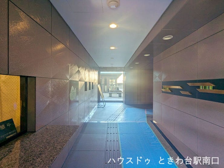 落ち着いた色合いのタイル張りエントランス。奥行きのある動線で、外部からの視線が気になりにくく、住まう方や来訪者を穏やかに迎え入れる共用空間です。