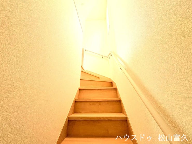 手すり付きの安心設計で、お子様からご高齢の方まで安全に昇り降りが可能です。階段スペースにも窓が配置されており、日中は照明なしでも足元が明るく、家全体に風を通す空気の通り道としても機能しています。