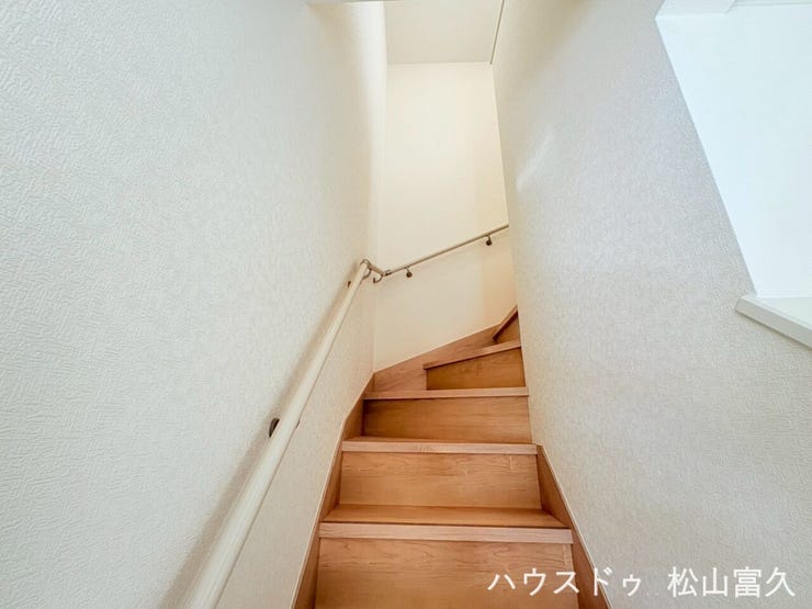 リビングからの動線がスムーズで、家族の気配を感じられる配置。窓からの自然光が差し込む明るく開放的な階段空間です