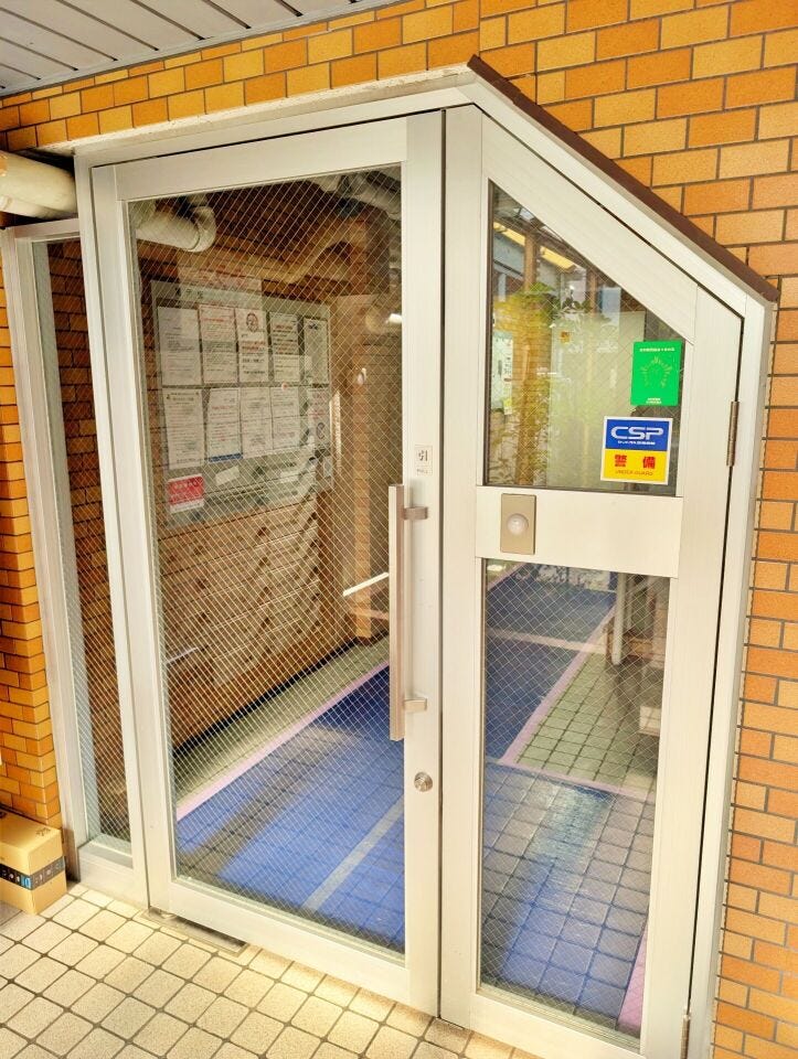 ガラス扉のエントランスで、外から中の様子が分かりやすい造りです。掲示物も整理されており、日常管理の様子が伝わってきます。