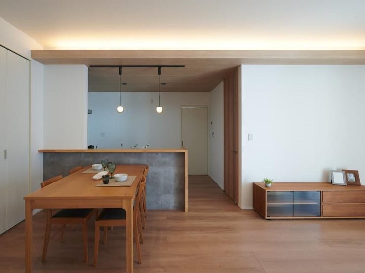 配膳や片付けがしやすく、家事効率と家族のコミュニケーションが高まる配置。キッチンの下がり天井から覗く間接照明のやさしい明かりが、家族の食卓を彩ります。