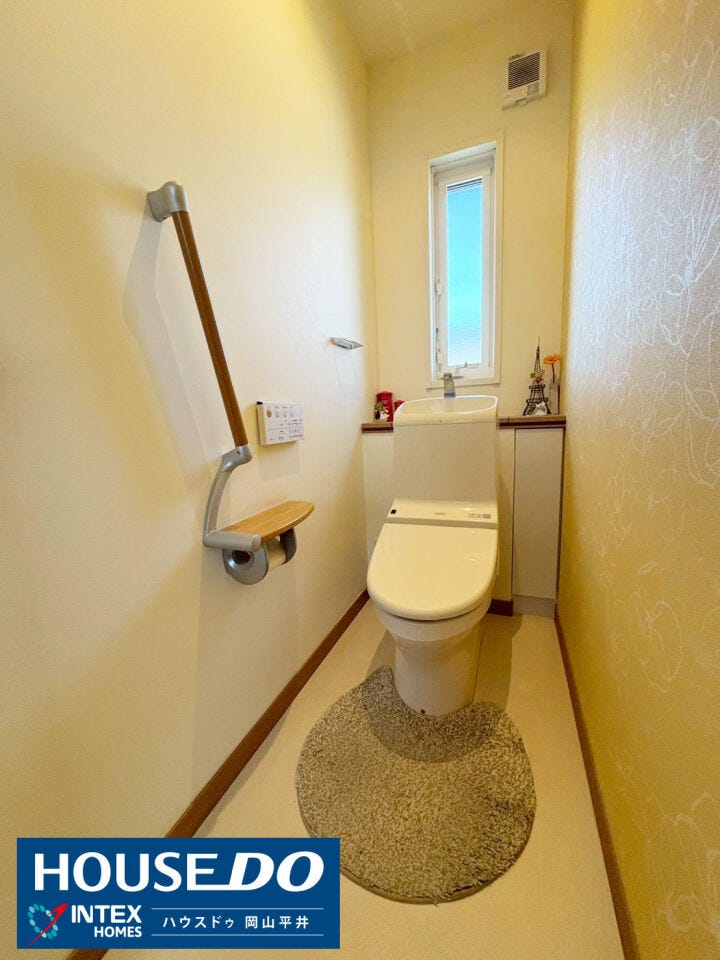 アクセントクロスがおしゃれな、落ち着いた雰囲気のトイレ。小窓付きで換気もしやすく、常に清潔な空気を保てます。手すりや便利な収納棚も完備されており、家族みんなが安心して使える優しい設計。