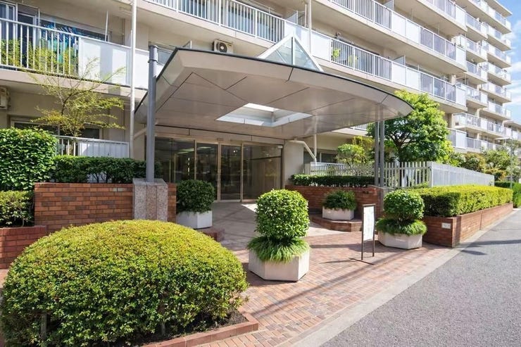 手入れの行き届いた植栽に囲まれたエントランス。屋根付きで雨の日も安心して出入りでき、清潔感と高級感のある共用空間が魅力です。