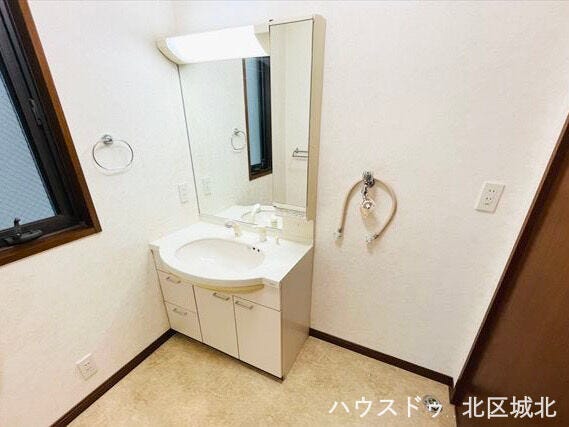 1階洗面所。三面鏡付き洗面台で収納豊富、朝の身支度もスムーズに行えます。