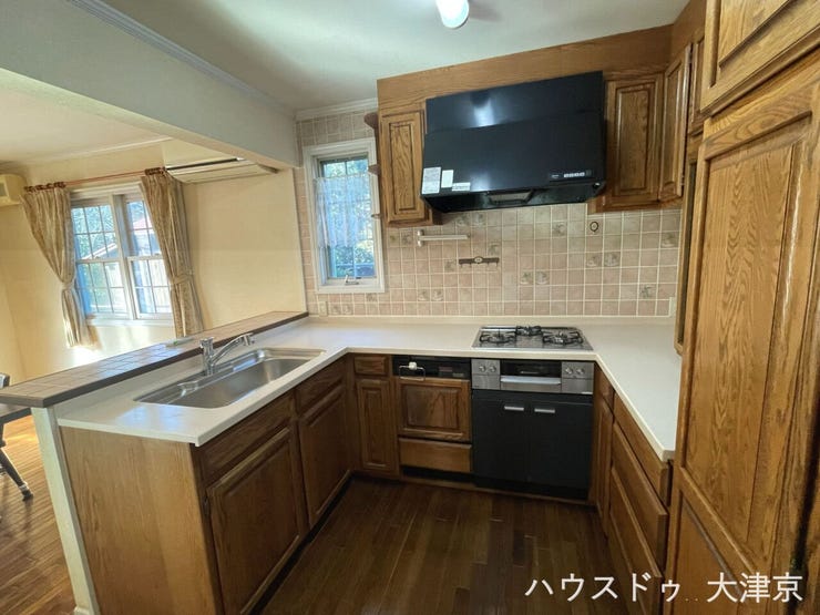 質感豊かな木目調キャビネット。リビングと繋がる開放的なキッチン。