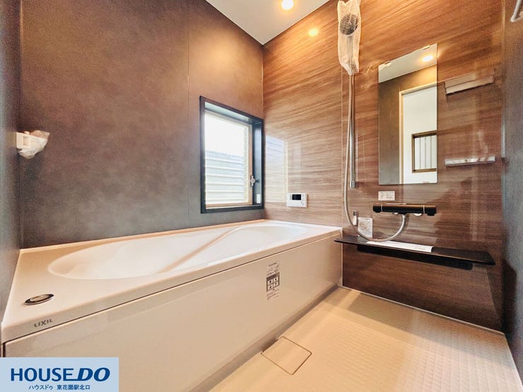 木目調のアクセントパネルが落ち着きを与えるバスルーム。足を伸ばして浸かれる浴槽には手すりが付いており、日々の入浴を安全にサポートします。窓からの自然換気も可能で、カビの発生を抑えられます。