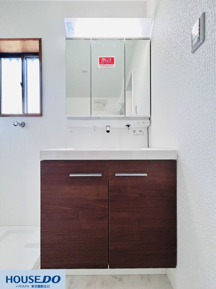 手入れのしやすいスクエア型の洗面ボウルを採用。下部の収納は開き扉タイプで、バケツや掃除用具などの大きな物も楽に収まります。ダークブラウンのパネルが、水回りに落ち着いた雰囲気を与えています。