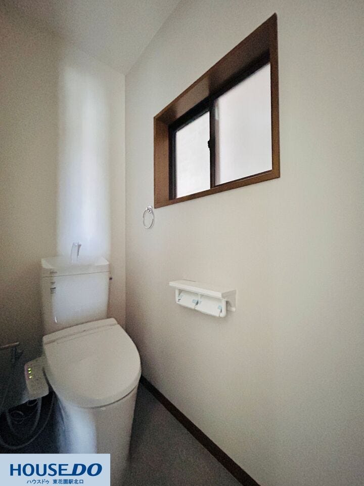 トイレはグレーのアクセントクロスが落ち着いた雰囲気を演出。清掃性が高く、日々のお手入れがスムーズです。小窓からの採光と換気機能、上部の棚など、使い勝手に配慮した設備が整っています。