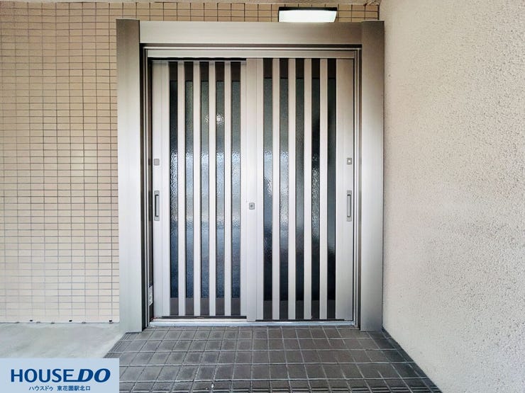 スリットから光を採り込む玄関引き戸。鍵穴が複数あり、防犯面への配慮がなされています。落ち着いたシルバーの枠回りが、エントランス部分をシャープで清潔感のある印象に整えています。