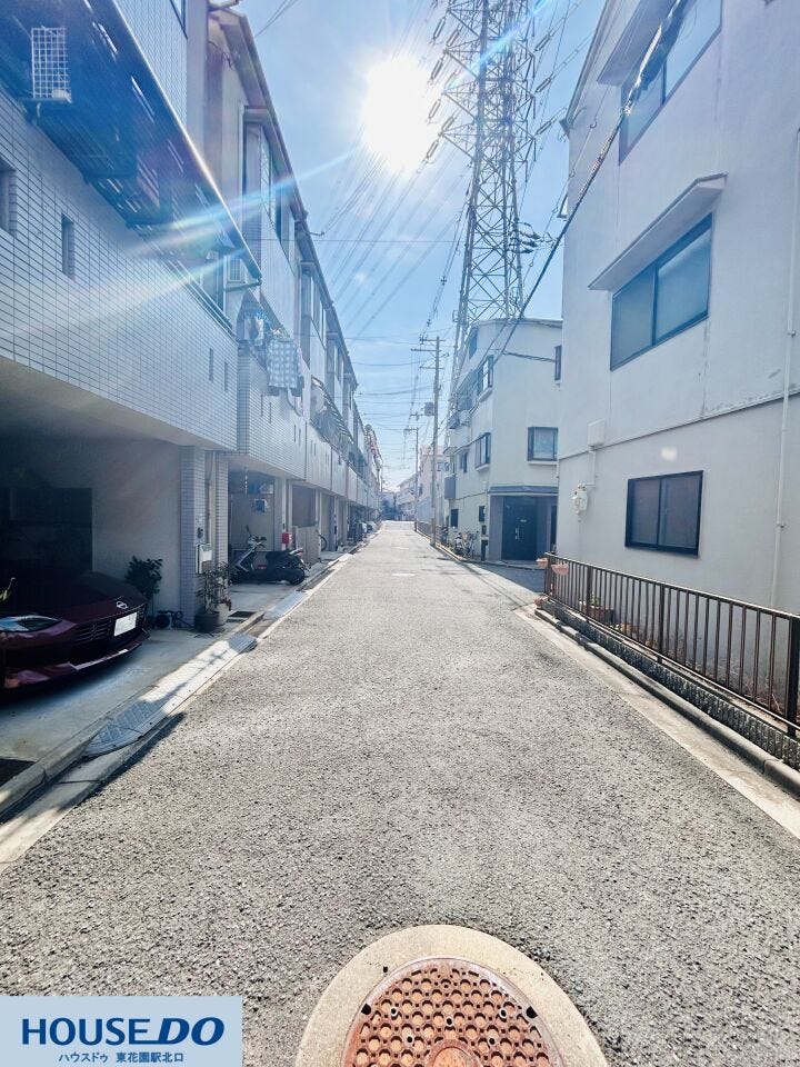 建物の間を通る直線的な通路は、隅々まで清掃が行き届き清潔感があります。電柱や配線も整理されており、空が広く感じられる設計。日当たりを妨げない配慮がなされた、風通しの良い住環境が整っています。