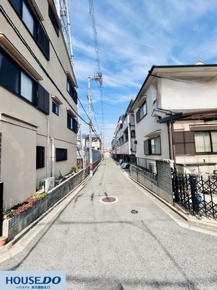 建物の間を通る直線的な通路は、隅々まで清掃が行き届き清潔感があります。電柱や配線も整理されており、空が広く感じられる設計。日当たりを妨げない配慮がなされた、風通しの良い住環境が整っています。