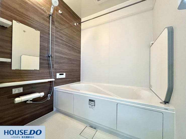 木目調の壁パネルが落ち着いた空間を演出する浴室です。ゆったりと足を伸ばせる浴槽や、天候を気にせず洗濯物を乾かせる浴室乾燥機を完備。日々の疲れを癒やす、心地よいリラックスタイムを提供します。