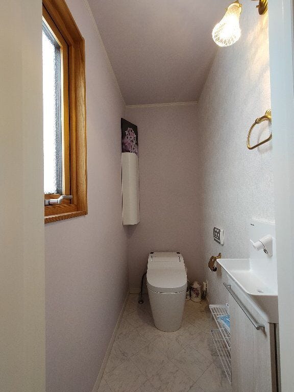 タンクレスのすっきりとしたデザインのトイレとなっており、こちらの照明も北洋風のおしゃれな照明が取り付けられております。