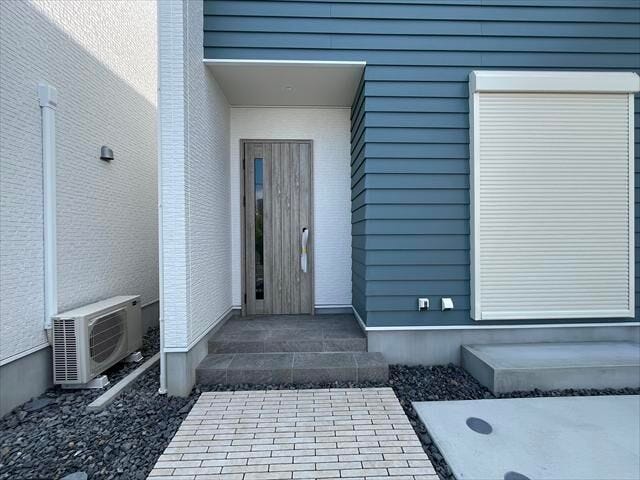 モダンデザインの新築一戸建て。広々とした玄関ポーチとおしゃれな玄関ドアが印象的な住まいです。
