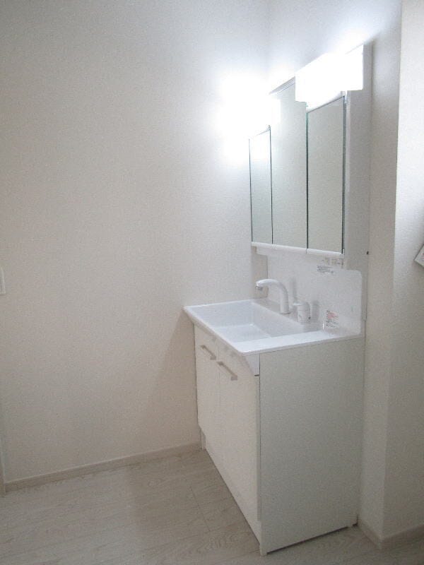 三面鏡の洗面化粧台は鏡扉の裏収納でたっぷりの容量をスッキリと収納できます。シャワーヘッド付きでお掃除も楽ちんです。