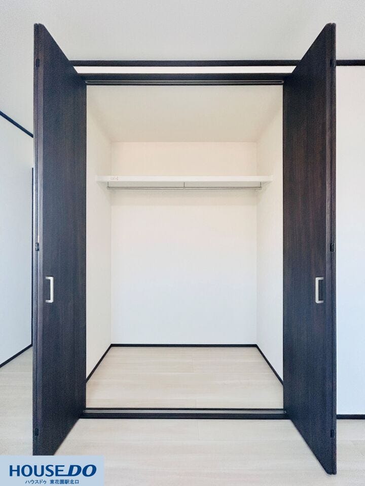 ハンガーパイプと上部棚を備えたクローゼットは、丈の長い衣類から小物まで効率よく整理できます。足元までゆとりがあるため、収納ボックスを置くなど、持ち物の量に合わせた柔軟な使い方が可能です。