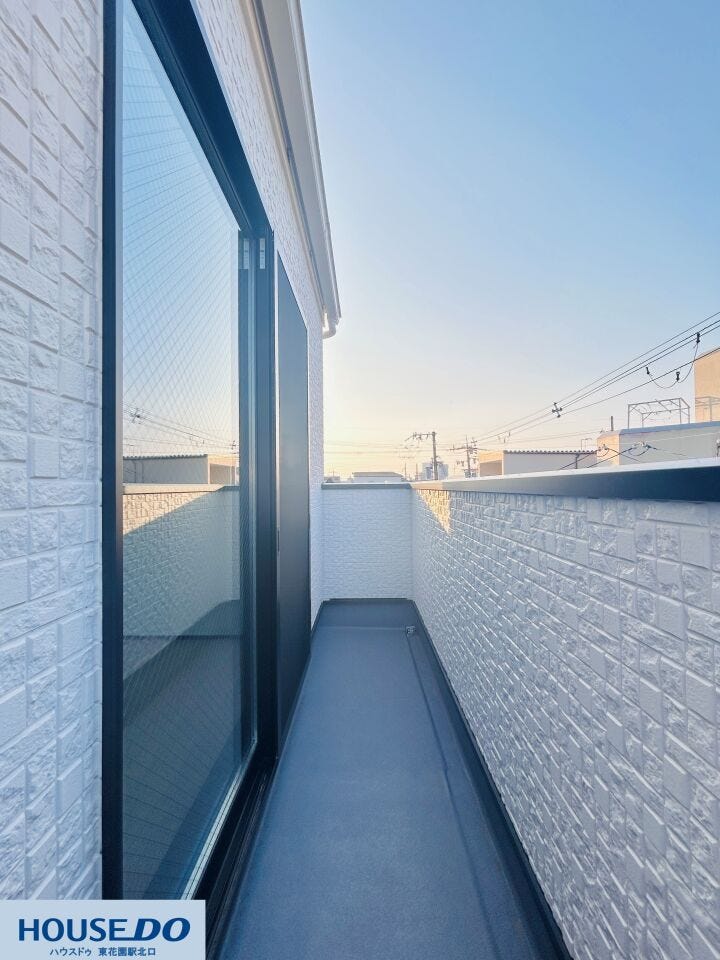 奥行きのあるバルコニーは、洗濯物を干す際にも動きやすいゆとりのある設計です。白い外壁が日光を反射して明るい印象を与え、外の空気を感じながら家事を進めることができます。