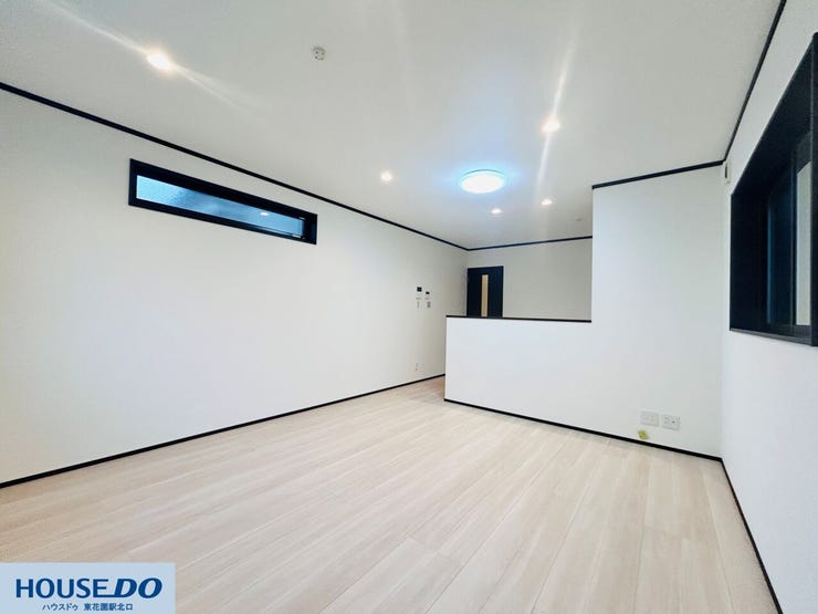 白を基調とした壁面に、黒のラインがアクセントを加えるモダンな内装です。ダウンライトが天井をフラットに見せ、視覚的な広がりを演出。木目調のフロアが足元から温かみを感じさせ、穏やかな空間を作り出します。