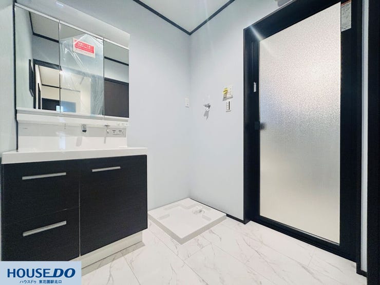 白を基調とした清潔感のある洗面室です。三面鏡の裏側はすべて収納になっており、散らかりがちな洗面小物もすっきりと片付きます。大理石調のフロアは水に強く、日々のお掃除も手軽に行える実用的な設計です。