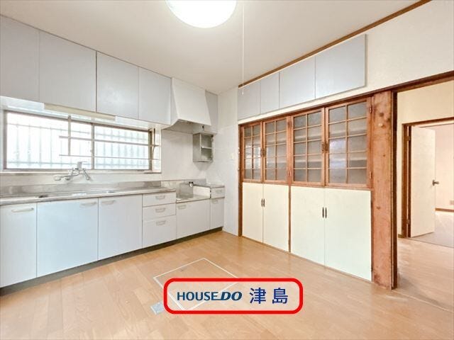 大きな掃き出し窓が設置され、明るいダイニングキッチン。白いシステムキッチンは室内を明るくしてくれます。