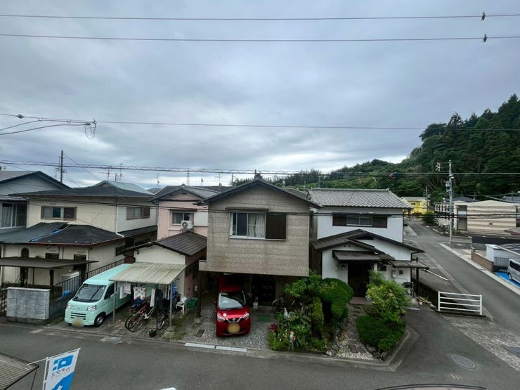 前方への視界が開けた眺望が特徴です。遮る高い建物がなく、周囲の住宅街や背景の緑豊かな山々が広がる景観となっています。開放感のある配置です。