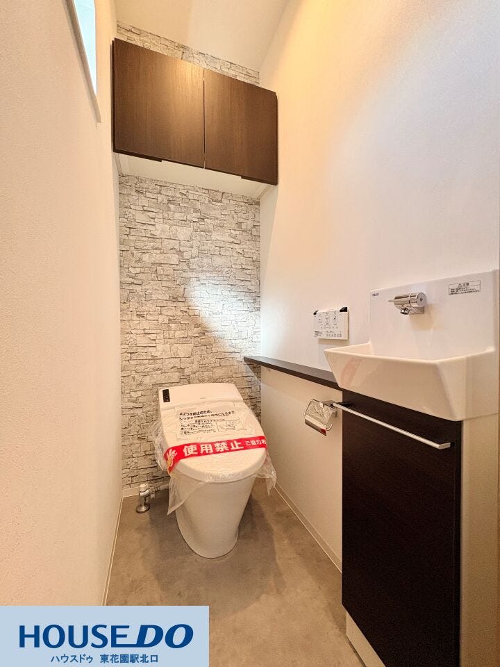 専用の手洗いカウンターを備えた、清潔感あふれるトイレ♪ レンガ調のアクセントクロスが温かみを添えています!上部の扉付き吊戸棚は、備品を隠して収納できるため、空間の美しさを保ちやすい設計です!