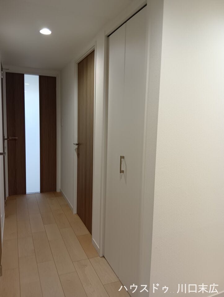 各居室へと繋がる、落ち着きのある廊下。日常の動線上に便利な収納を備えており、掃除用具や日用品のストックなどをすっきりと片付けることができます。