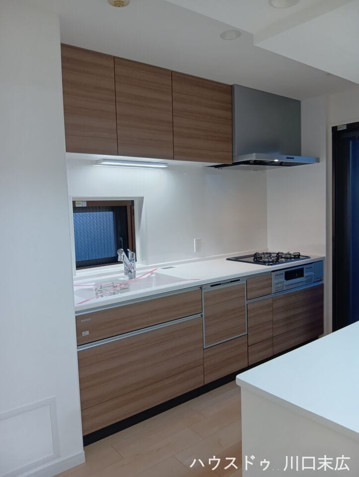 木目調のパネルが空間に温もりを添える、デザイン性と機能美を両立したキッチンスペース。お手入れしやすい素材を採用し、日々の家事負担を軽減する工夫が満載です。