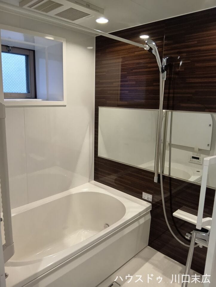 木目調のアクセントパネルが落ち着きと高級感を演出するバスルーム。一日の疲れをゆったりと癒やす、上質でリラクゼーションに満ちたプライベート空間です。