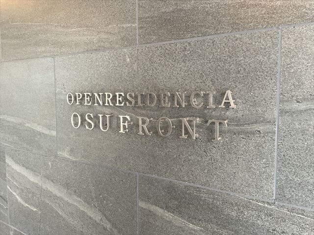 重厚感あるタイル壁に映える館銘板。上質なデザインが建物のグレード感を印象づけます。