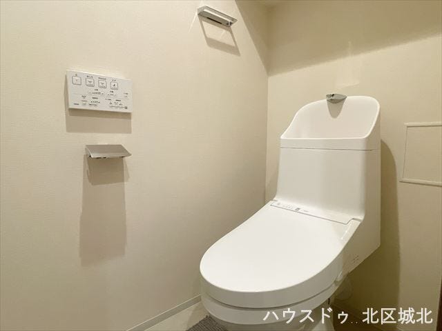 温水洗浄機能付きの清潔感あるトイレ。壁付けリモコンで操作もラクラク、毎日快適に使える設備です。