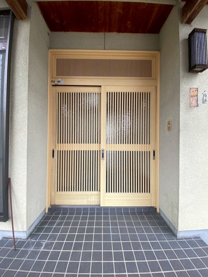 趣ある格子引き戸の玄関が印象的な住まい。屋根付きで雨の日も安心、和の温もりを感じる落ち着いたエントランスです。
